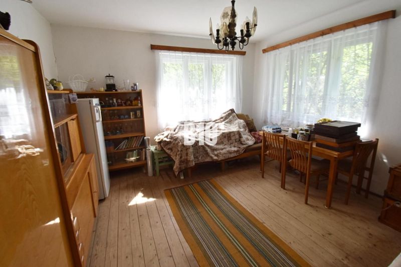 Nappali egy családi házban, fa dekoros padlóval, kanapéval és asztallal.