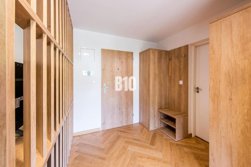 Fa dekorációjú előcsarnok, fa dekorációjú ajtók és padló a nyaraló apartmanban.