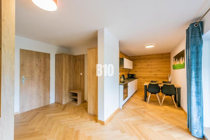 Konyha és étkező egy nyaraló apartmanban fa dekor padlóval.