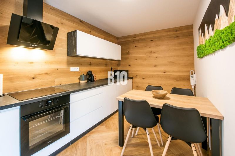 Konyha a Nyaraló apartmanban fa dekor padlóval és stílusos bútorokkal.