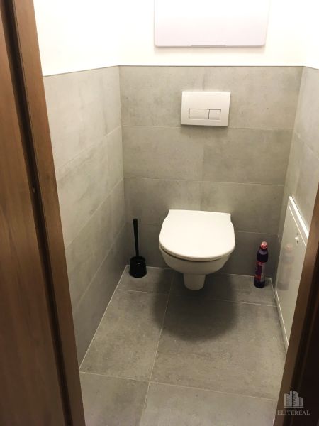 Fürdőszoba egy kétszobás lakásban csempével és fali WC-vel.
