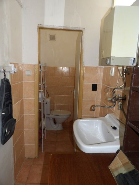 Két szobás lakás fürdőszobája WC-vel és mosdóval egyszerű stílusban.