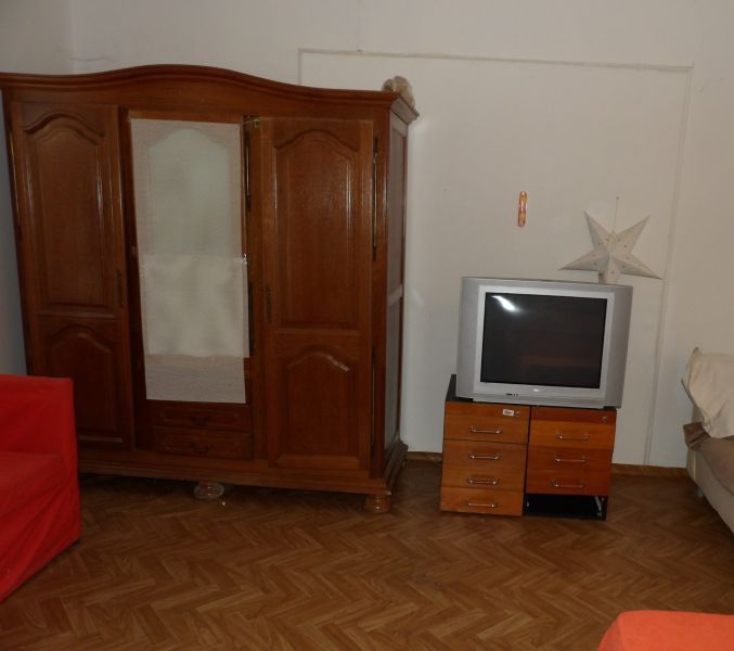 Szoba egy kétszobás lakásban fa bútorokkal és fa dekorációjú padlóval.