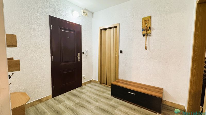 Egy 4 szobás lakás belső tere fehér falakkal, fa dekoros padlóval és sötét ajtókkal.