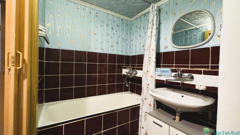Fürdőszoba zománcozott káddal és csempézett burkolattal egy 4 szobás lakásban.