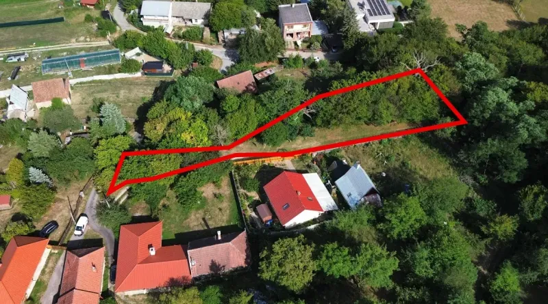 Légi felvétel a kolačnai kertekben található telkekről, amelyeket zöldterületek és házak vesznek körül.