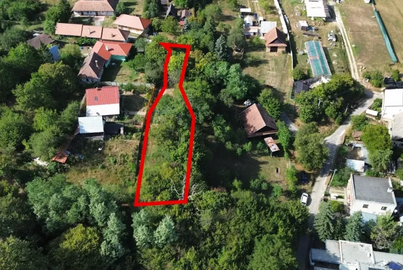 Légi felvétel a Kolačnában található kertekről, amelyeket házak és zöldterületek vesznek körül.