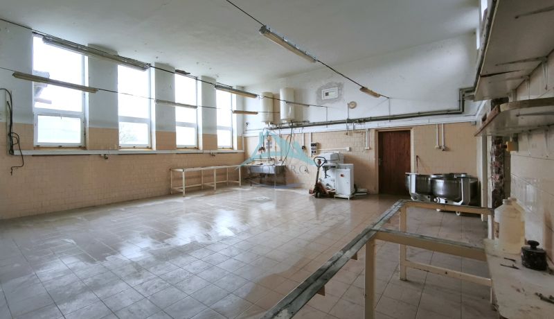 Gyártóhelyiségek belső tere csempével, berendezéssel és nagy ablakokkal.