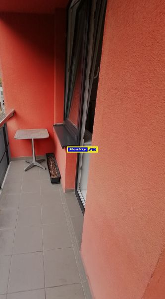 Erkély piros falakkal egy kétszobás lakásban a Nábrežná utcában, Vrútkyban.