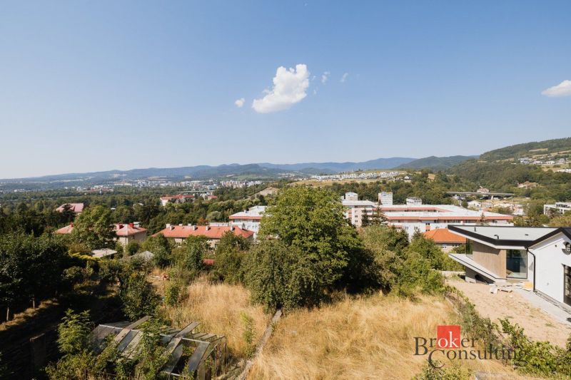 Kilátás egy családi házra Besztercebányán, a Komenský utcában és a környező dombokra.