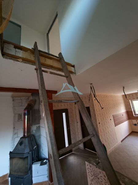 Családi ház belső felújítása, ahol a lépcső és a fatüzelésű kályha dominál.