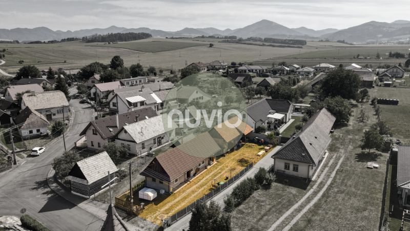 Családi házak madártávlatból a mezők és hegyek által körülvett Zsabokrek településen.