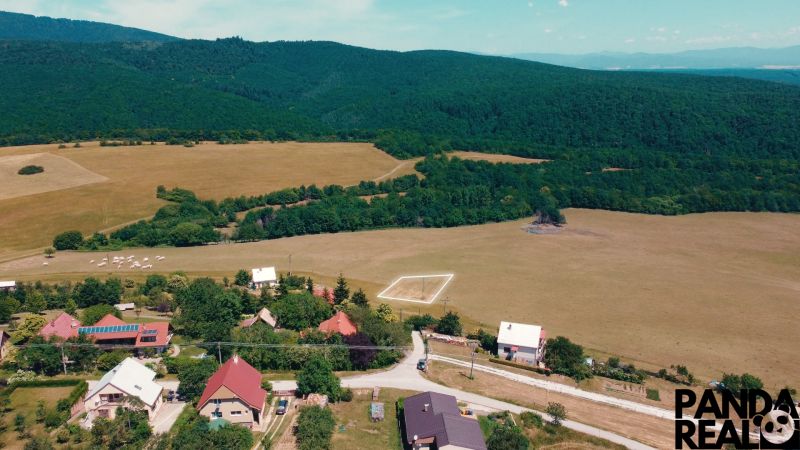 Vidékies kilátás a Podhradí lakóterületeire, amelyeket erdők és rétek vesznek körül.