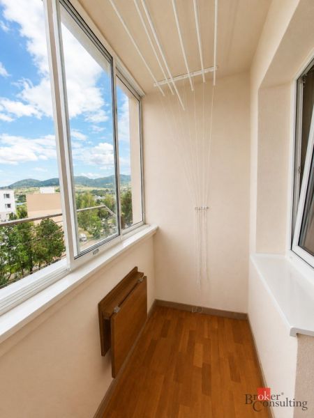 Fürdőszoba egy háromszobás lakásban káddal, mosógéppel és mintás csempékkel.