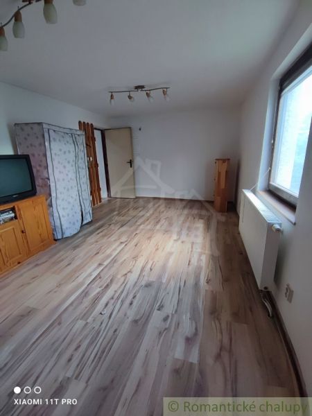 Szoba családi házban televízióval és fa dekorációjú padlóval.