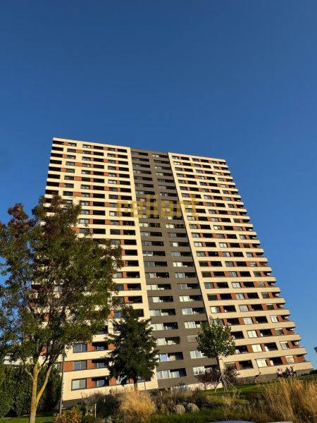 Magas épület a pozsonyi Bosák utcában, Pozsony-Petržalka városrészben, zöldövezet veszi körül.