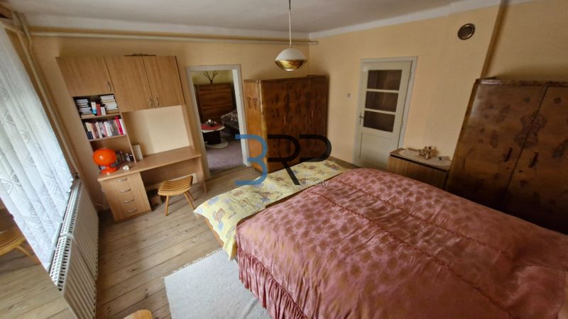 Hálószoba családi házban fa dekorációval és antik bútorokkal.