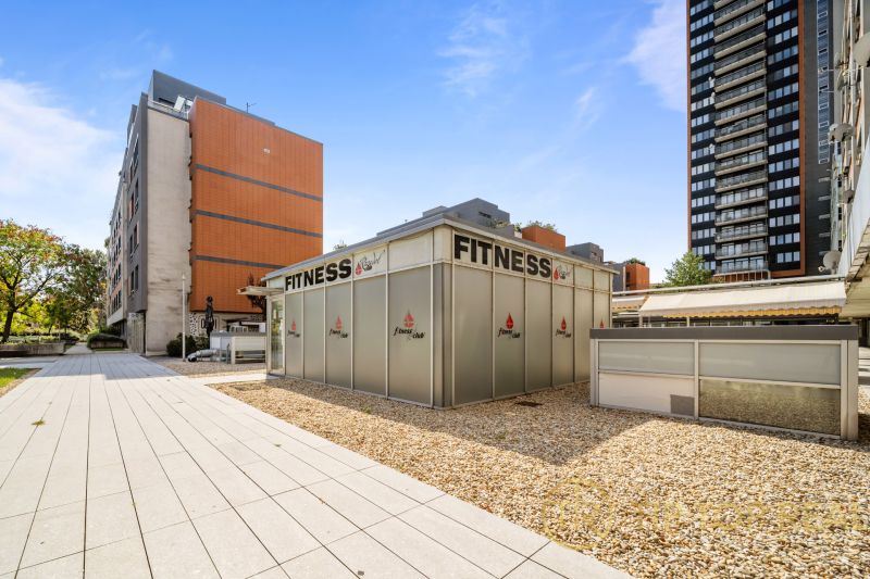 Pozsony - Nivy, Trenčianska: Fitneszközpont, amelyet modern épületek és burkolt területek vesznek körül.