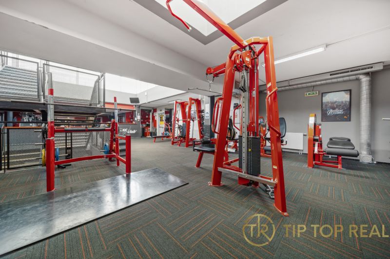 Fitneszközpont súlyzókkal és edzőgépekkel, üzlethelyiségek.