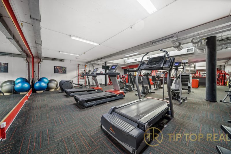 Fitneszközpont futópadokkal és edzőeszközökkel kereskedelmi helyiségekben.
