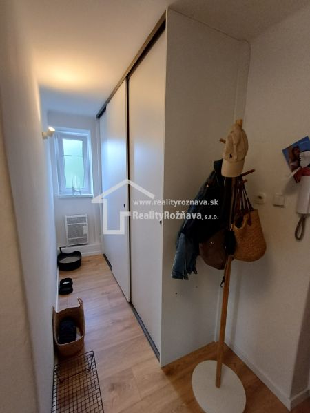Folyosó egy kétszobás lakásban, fa dekorációjú padlóval és beépített szekrényekkel.
