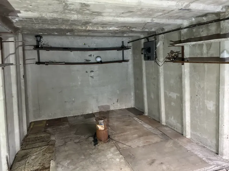 Betonszoba falitartókkal és fa dekorációjú padlóval a garázsokban.