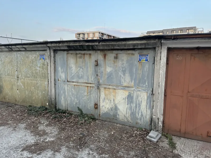 Elhagyatott garázsok Pozsony-Újvárosban, lehullott vakolattal és bádogajtókkal.