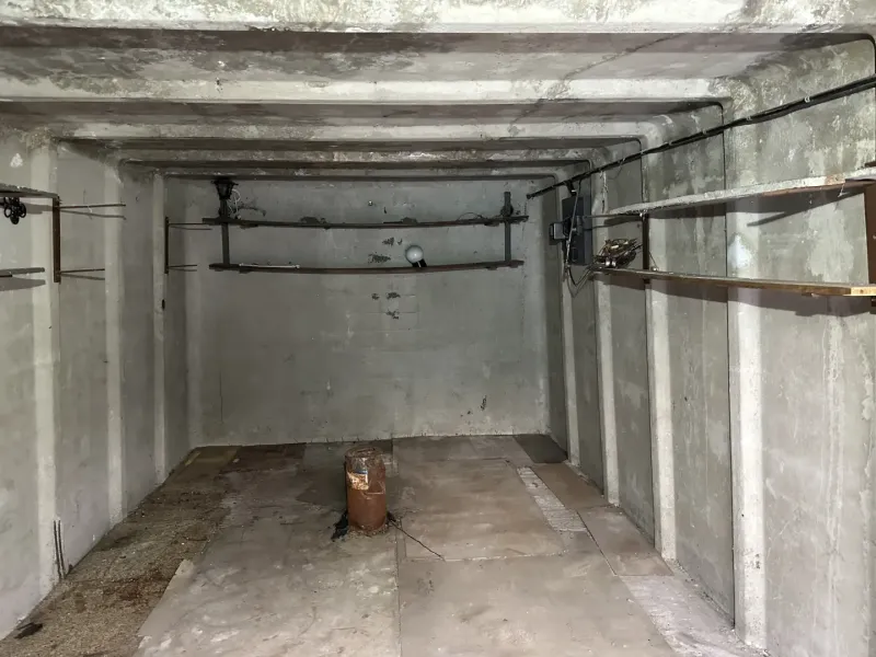 Üres beton garázs belső tér polcokkal és világítással.