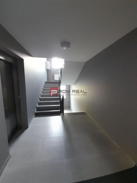 Folyosó lépcsőházzal és lifttel egy kétszobás lakásban.