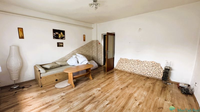 Nappali egy családi házban, kanapéval és fa dekorációjú padlóval.