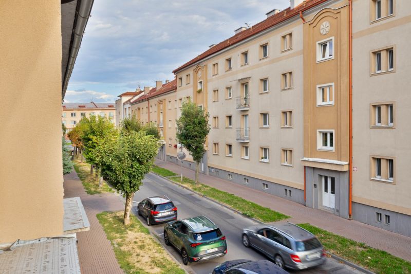 Študentská utca Zvolenben, lakóházakkal és elhaladó autókkal, garzonlakásra alkalmas.