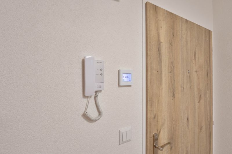Fa dekorációjú ajtók és kaputelefon a garzonlakásban.