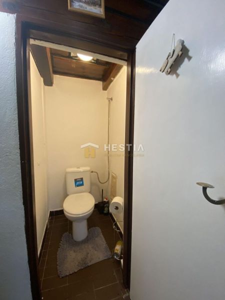 WC egy családi házban sötét padlólappal és fehér falakkal.