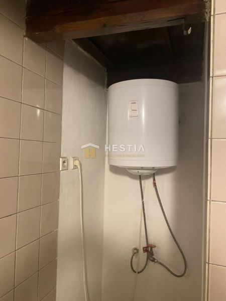 Bojler egy családi házban, kerámia csempékkel a falon.