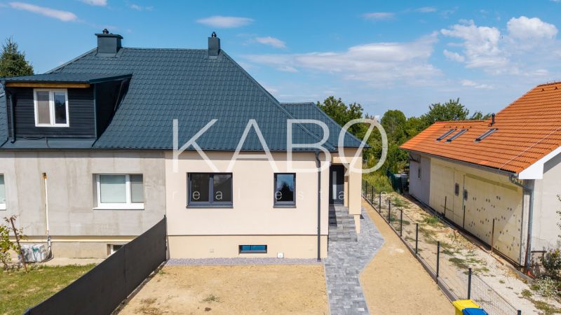 Családi ház a Nyitrai Trnavská utcában sötét tetővel és rendezett udvarral.