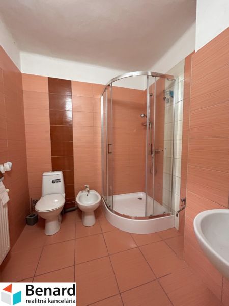 Fürdőszoba családi házban: zuhanyzó, WC, bidé, meleg tónusú csempék.