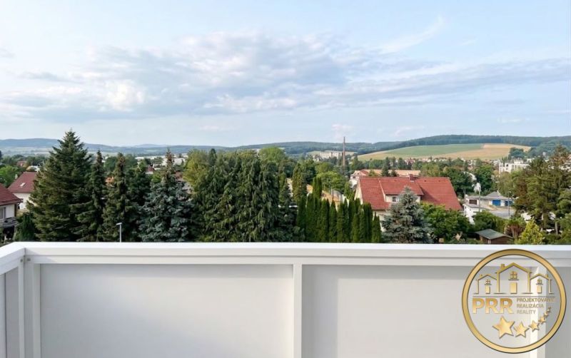 Kilátás a zöldre és a tetőkre Bánovce nad Bebravou-ban egy 2 szobás lakásból.