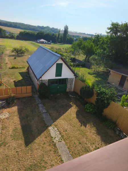 Kert és épület egy családi ház mellett Jelenecben, mezők és fák ölelésében.