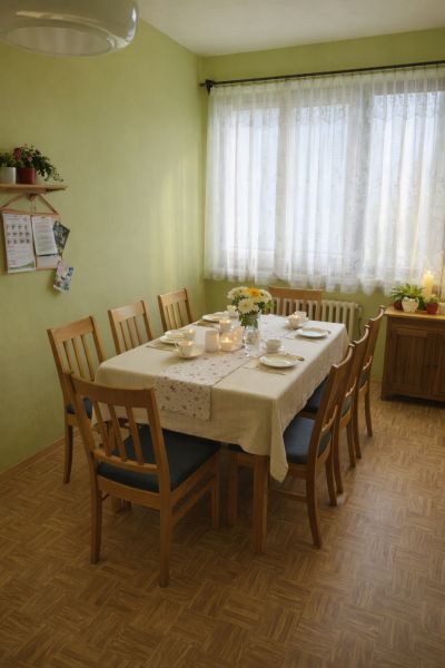 Ebédlő egy családi házban, megterített asztallal és fa dekorációjú padlóval.