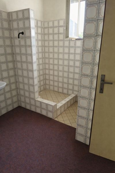 Fürdőszoba családi házban retro csempékkel és zuhanyzóval.