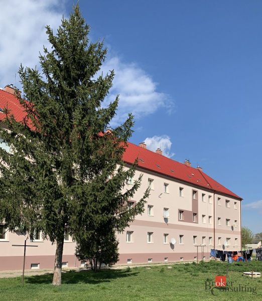 Épület piros tetőkkel és előtte egy fa, a Vasút utcán Ipolyságon.