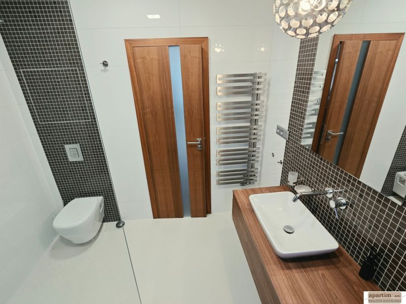 Fürdőszoba függesztett WC-vel, mosdóval és radiátorral egy 4 szobás lakásban.