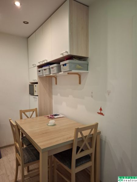 Étkező sarok asztallal és székekkel egy háromszobás lakásban. Fa mintázatú padló.