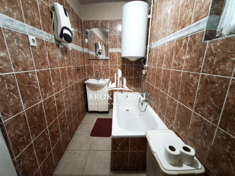 Fürdőszoba családi házban barna csempékkel és káddal.