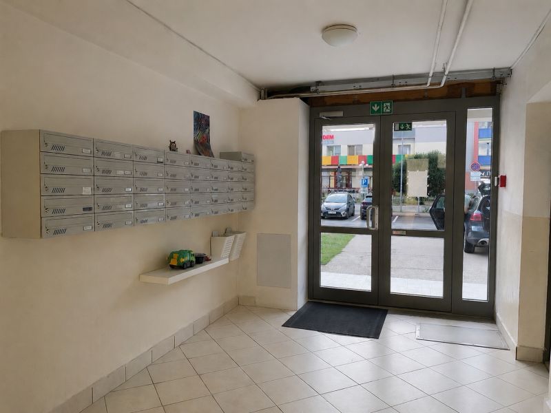 A 3 szobás lakás előcsarnoka postaládákkal és üvegezett ajtókkal.