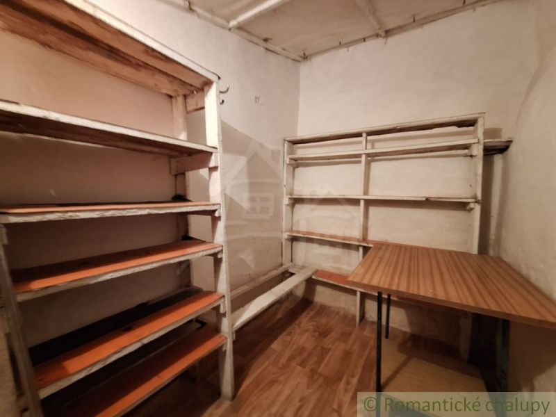 Polc és asztal egy családi ház belsejében, fa dekorációjú padló.