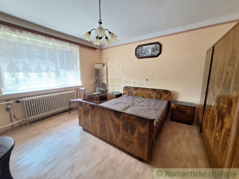 Hálószoba családi házban, fa dekorációjú padlóval és stílusos bútorokkal.