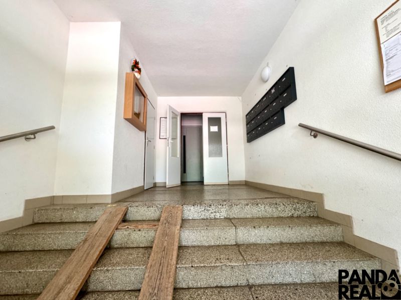 Társasház előcsarnoka postaládákkal és lifttel.