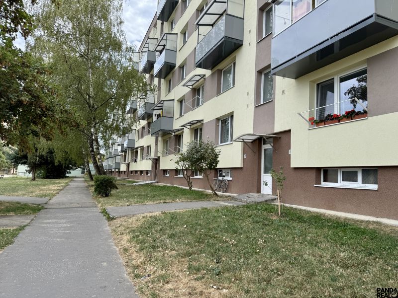 Lakóház zöldterülettel és járdával, Topoľčanyban található, fákkal körülvéve.