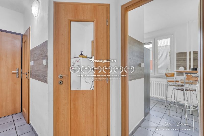 Egy 2 szobás lakás belső tere faajtókkal és üvegezett bejárattal a konyhába.